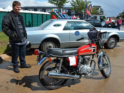 1975 Honda CV 360 Motorcycle, with a man standing next to it in leathers and holding a helmet 