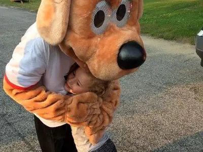 Police Dog mascot hugging a small Caucasian girl