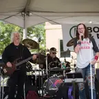 Band on stage, drummer, guitarist and lead singer