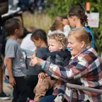 Older female sitting in a lawn chair with young boy in her lap watching the Happy Days parade