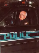 Former Chief Auspos sitting in a police car. 