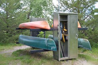 Canoe and Kayak rental station at Sunfish Lake Park, 2 canoes and 2 kayaks in a locked rack