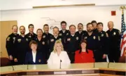 13 police officers in the back two rows and three office technicians in the front row. 