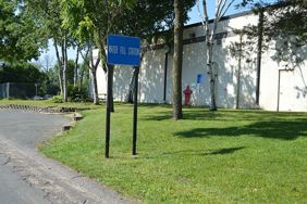 Water Fill Station on Jasper Street with directional sign in front of cinder block building