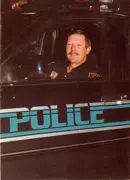 Former Officer Balabon sitting in a police car. 