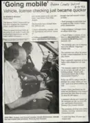 Newspaper article of new police technology. Police Chief showing off technology to council member.