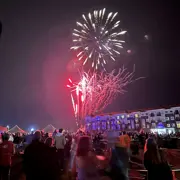 Crowd in the foreground watching two huge starburst fireworks explode