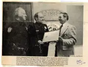 Officer Anderson in the middle receiving an award. Anoka and Ramsey Chiefs on the ends. 