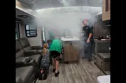 Children in a camper trailer with a fireman during a smoke demonstration