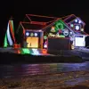 Split-level home with three car garage on left, decorated with LED holiday lights