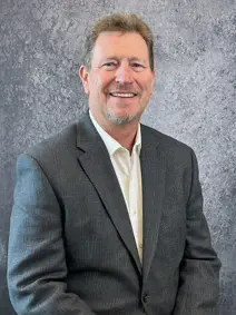 Council member Chris Riley smiling, wearing a sport coat and open collar shirt