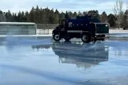 Water truck on a sheet of ice spraying water to flood it