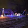 One-level home with two dormers, with yard decorated in holiday lights 