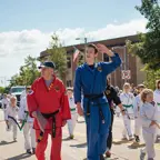 Adults and children walking in a parade Karate clothing 