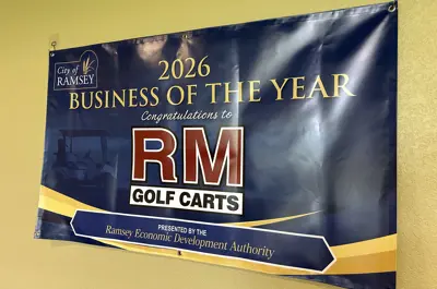 Blue banner reads Congratulations RM Golf Carts 2026 Business of the Year