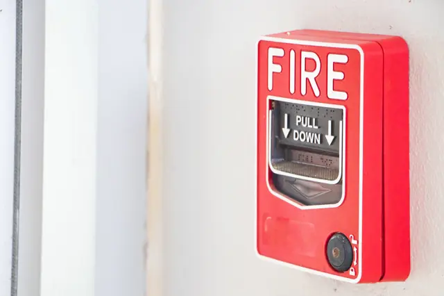 a generic wall mounted "PULL" fire alarm panel common in schools