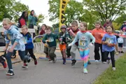 Start of the Fun Run race with enthusiastic children running in a group