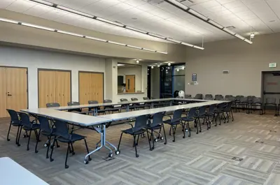 Alexander Ramsey Room 8 tables in a rectangular configuration, chairs a round it, kitchenette in back