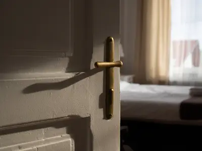 A panel door that is partially open to a bedroom