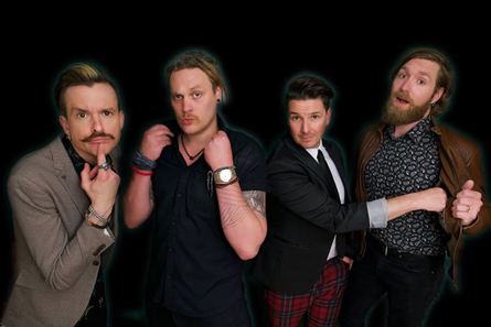 Four male band members in funny poses looking at the camera
