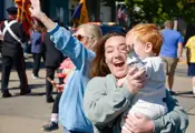 Woman laughing holding a toddler boy at the parade