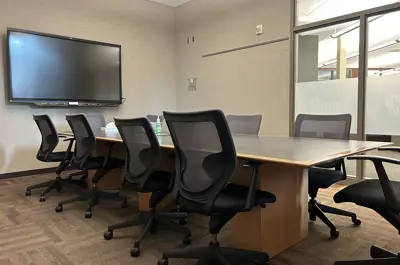 Trott Brook Room with conference table, ten chairs, flat screen on the back wall