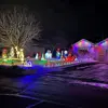 One-level home with garage on right, yard and house decorated in holiday lights.