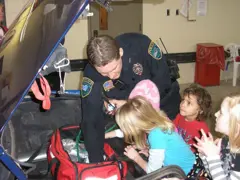 Office by a car with small children around them
