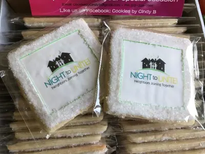 2 sugar cookies wrapped in plastic with night to unite logo on them
