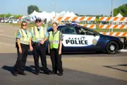 Police Reserves and Explorer outside wearing traffic vest standing in front of a police car. 
